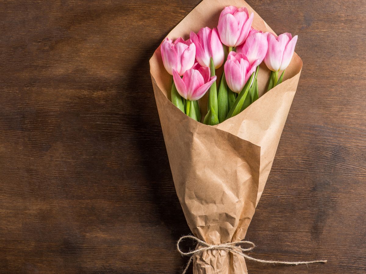 Bouquet of pink tulips wrapped in brown paper and tied with a string